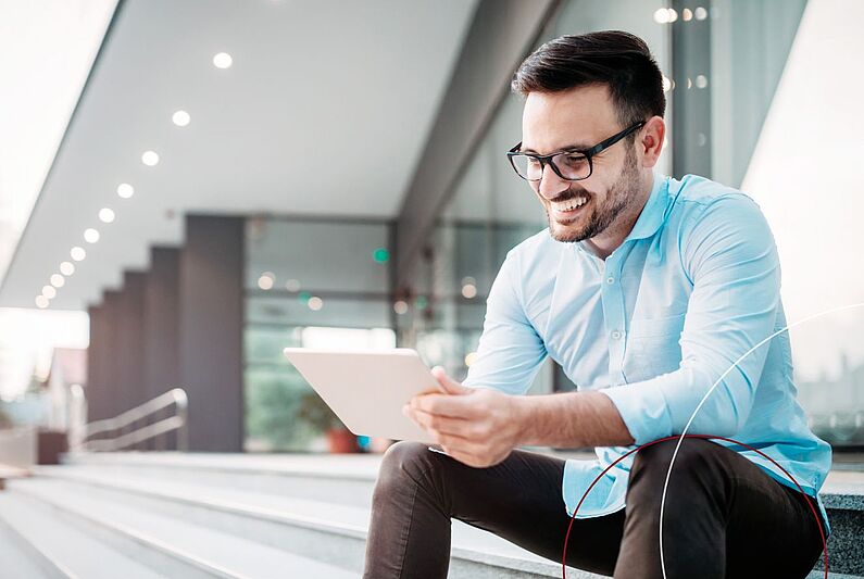 Mann sitzt mit Klemmbrett auf den Stufen.