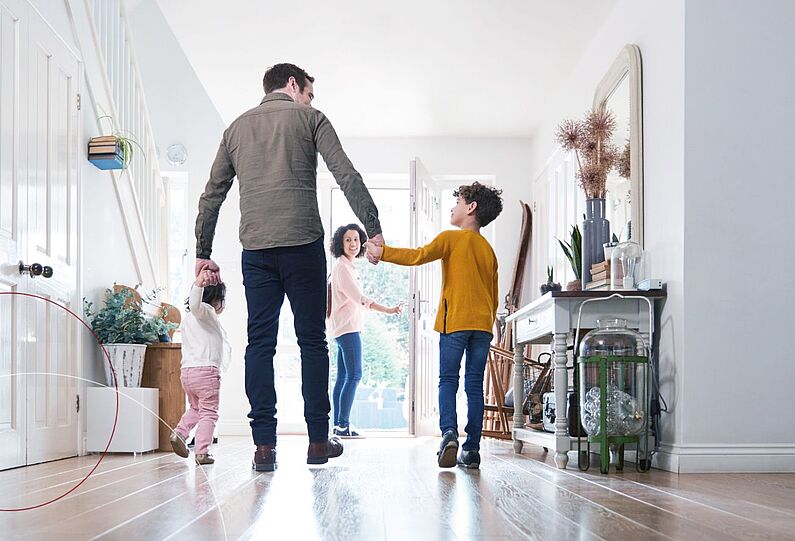 Eine Familie im Wohnzimmer auf dem Weg in den Garten.
