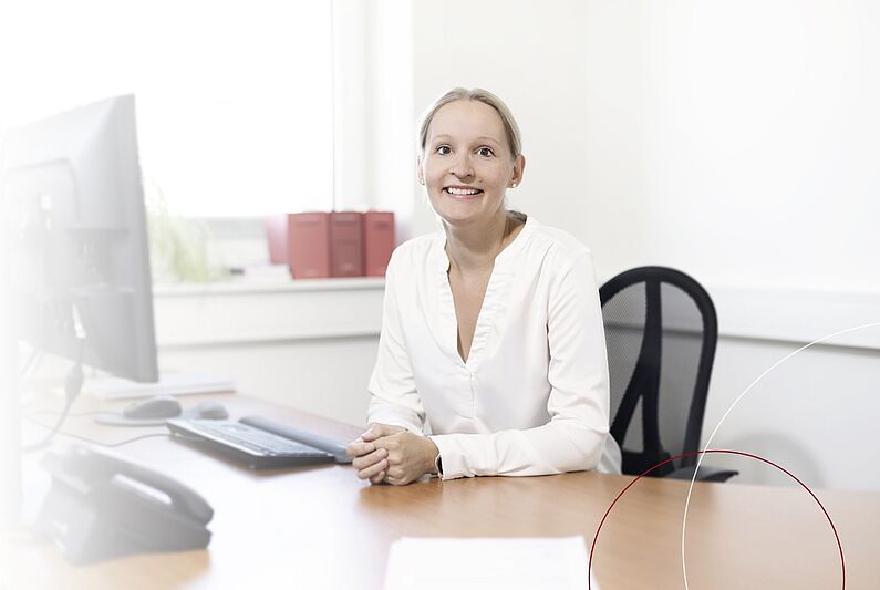 Kollegin Barbara Heller sitzt an ihrem Arbeitsplatz.