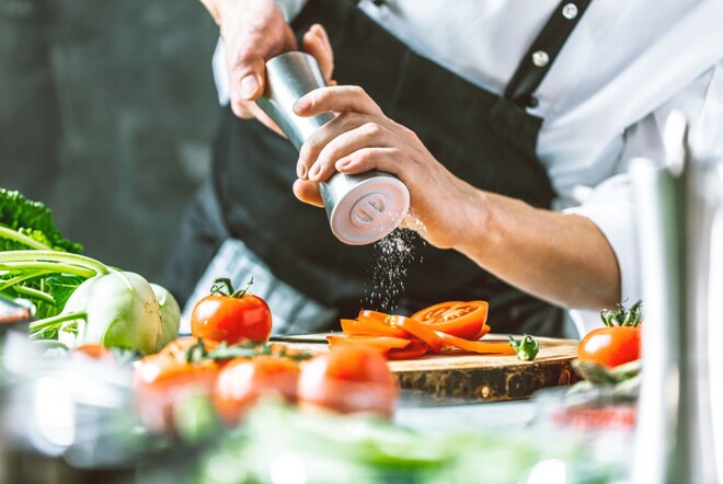 Ein Koch würzt sein Essen