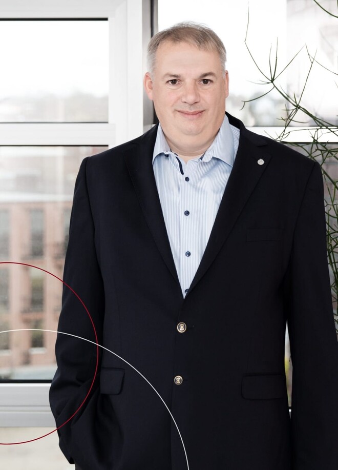 Thomas Grohmann vor einem Fenster stehend