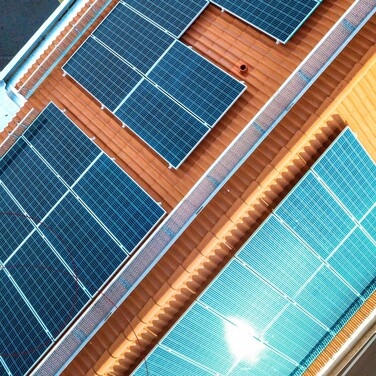 Ein rotes Ziegelsteindach mit blauen Solarplatten