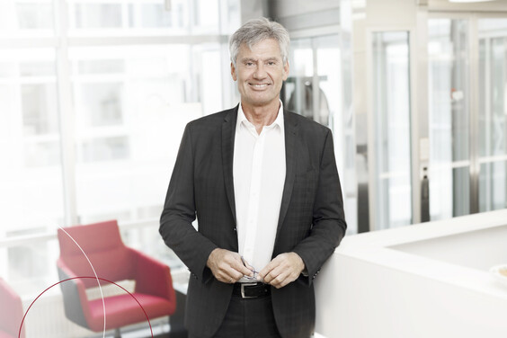 Ein ttpler mit weißen Hemd steht bei ttp im Büro