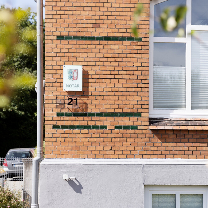 Blick auf ein notarielles Schild an der Fassade des Standort Schleswig