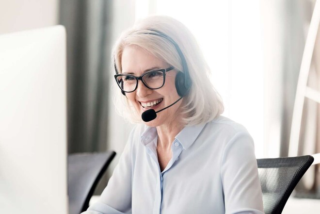 Eine ältere Frau trägt ein headset