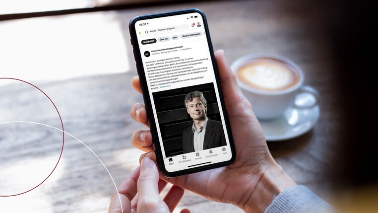 Hand mit Smartphone, auf dem die ttp-Homepage sichtbar ist