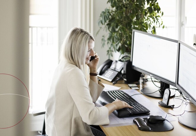 Eine Mitarbeiterin bei ttp sitzt an einem großzügigen Schreibtisch