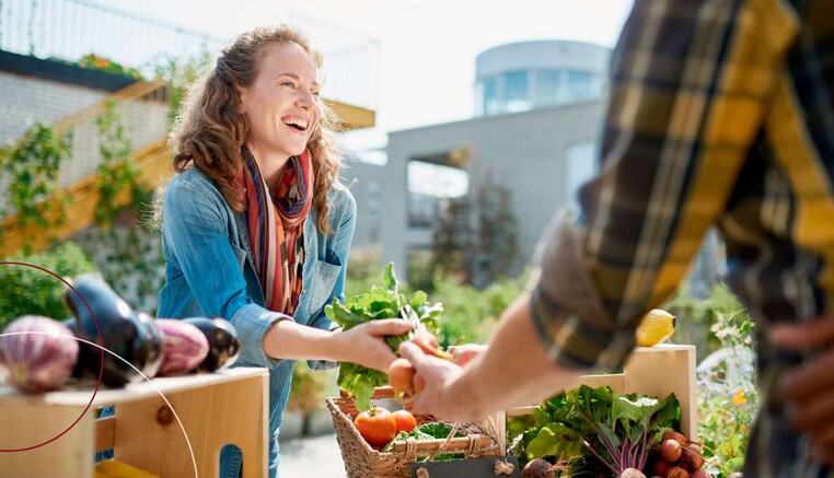 Eine Frau am Marktstand für Obst und Gemüse