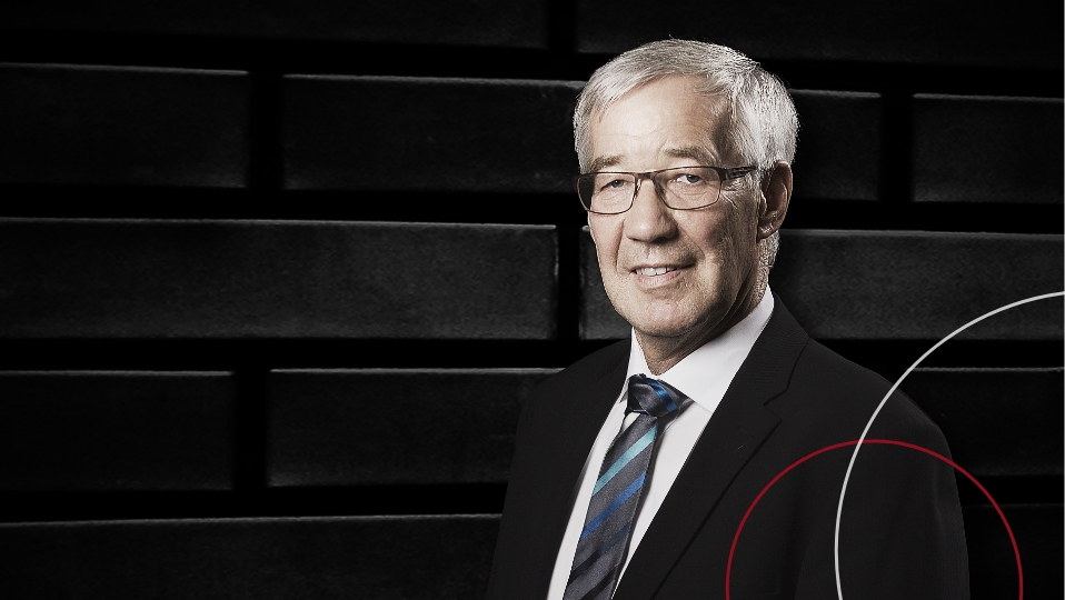 Steuerberater Werner Findeisen steht vor einem schwarzen Hintergrund