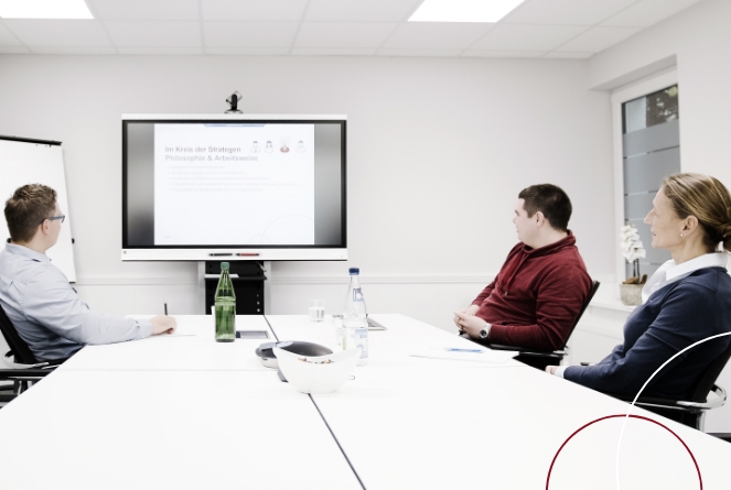 Drei Personen sitzen bei ttp im Konferenzraum